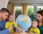 Eine Familie sitzt bei einem Globus und plant eine Reise in den Urlaub