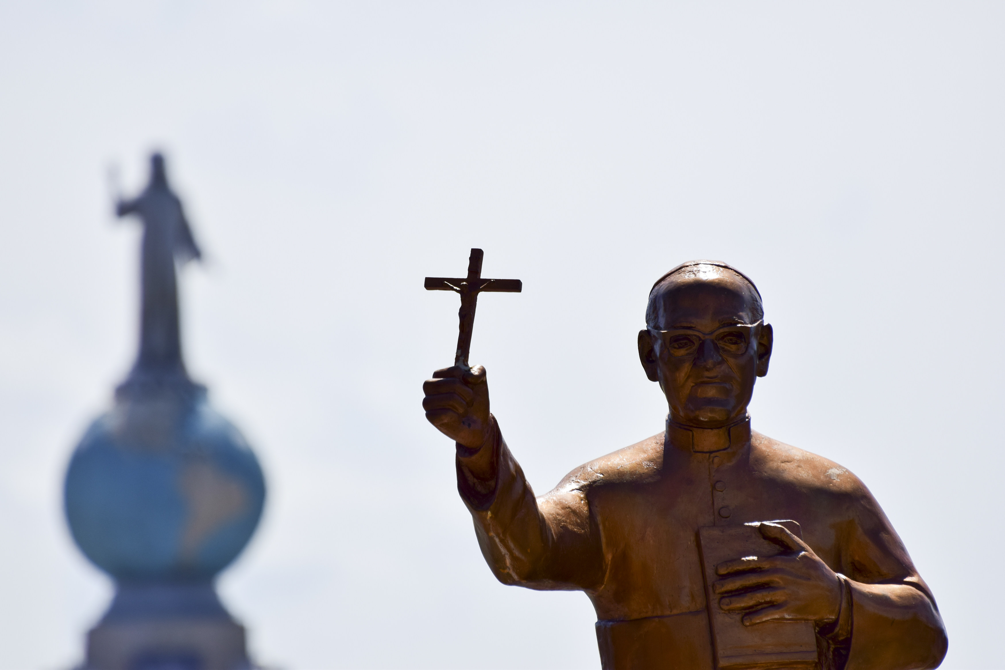 Eine Statue von Oscar Romero steht bei dessen Seligsprechung am 23. Mai 2015 in San Salvador vor dem Denkmal Monumento al Divino Salvador del Mundo, dem Wahrzeichen von El Salvador.