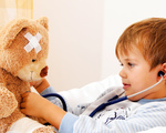 Ein Krankes Kind untersucht Teddy mit Stethoskop