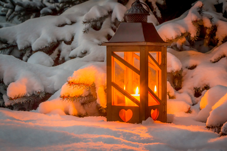 Eine Laterne leuchtet im Schnee zu Weihnachten. Romantisches Licht an einem Abend im Winter. Stille und Ruhe