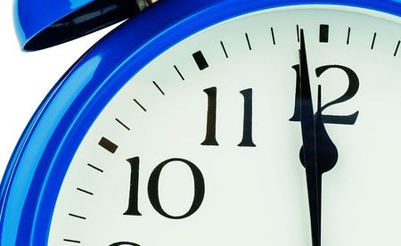 Ein blauer Wecker auf wei?em Hintergrund. F?nf vor Zw?lf