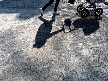 Schatten eirn Frau mit einem Kinderwagen. 