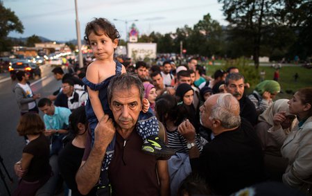 Flüchtlinge an der deutsch-österreichischen Grenze / © 2015 KNA, www.kna-bild.de - Nutzungsrechte vorbehalten., Lukas Barth Flüchtlinge warten am 16. September 2015 an der Grenze zwischen Deutschland und Österreich an der Saalbrücke in Freilassing, um von dort in eine Erstaufnahmeeinrichtung gebracht zu werden. Bild: Flüchtlinge drängen sich auf der Brücke. Ein Mann trägt