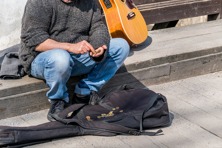 Ein Strassenmusiker zählt seine Einnahmen. Überleben als Künstler