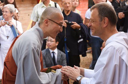 Frere Alois und Buddhist / © 2015 KNA, www.kna-bild.de - Nutzungsrechte vorbehalten., Alexander Brüggemann Frere Alois, Prior von Taize, begrüßt einen Vertreter des kambodschanischen Buddhismus am 16. August 2015 zur Gebetsfeier am zehnten Todestag des Taize-Gründers Frere Roger.