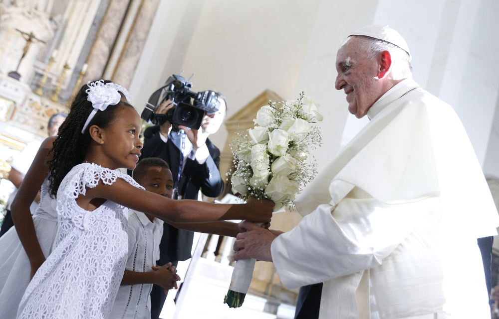 Ein Mädchen in weißem Kleid überreicht Papst Franziskus weiße Blumen, bei dessen Besuch im Heiligtum San Pedro Claver in Cartagena am 10. September 2017.