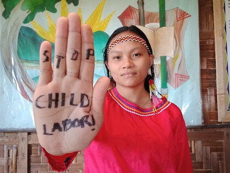 Aktivistin signalisiert 'Kinderarbeit stoppen'