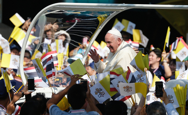 Menschen schwenken Vatikan-Flaggen bei der Ankunft von Papst Franziskus im Papamobil am 22. November 2019 in Bangkok.