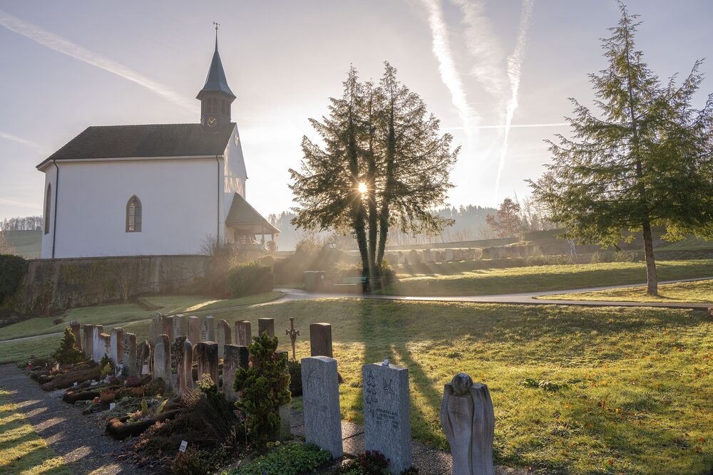 Kirche mit kleinen Friedhof im Sonnenaufgang