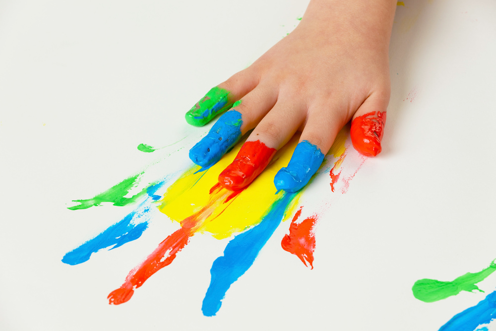 Ein kleines Kind malt mit Fingerfarben. Lustig und Kreativ.