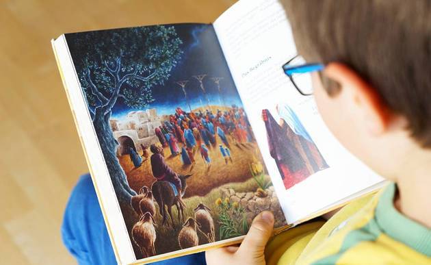 Kind liest Bilderbibel / kathpress / Pernsteiner