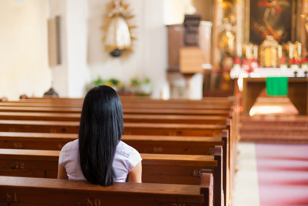 Junge Frau betet in einer Kirche