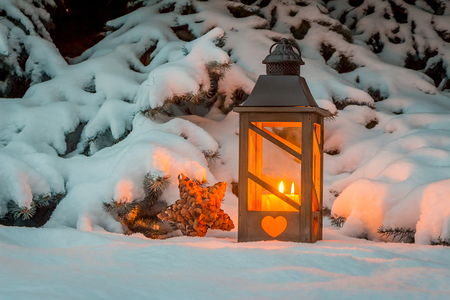 Eine Laterne leuchtet im Schnee zu Weihnachten. Romantisches Licht an einem Abend im Winter. Stille und Ruhe