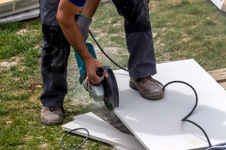 Fliesenleger bei der Arbeit / Erwin Wodicka - wodicka@aon.at, Erwin Wodicka Ein Fliesenleger bei der Arbeit. Zerschneidet Platten mit einer Trennscheibe