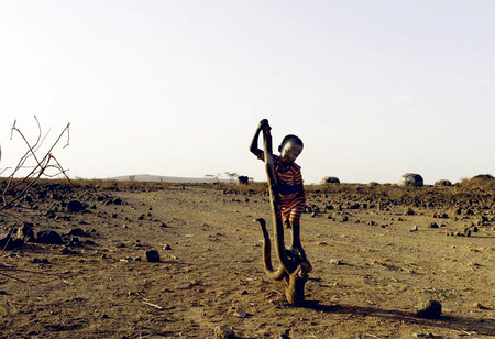 Afrikanisches Kind in trockener Landschaft