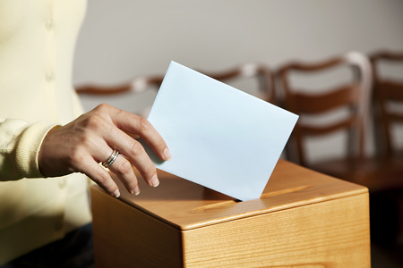 Eine junge Frau bei einer Wahl in der Wahlzelle. Stimmabgabe in der Demokratie