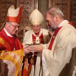 Dompropst Vieböck überreicht dem neuen Bischof ein Kreuz zum Kuss
