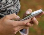 Eine junge Frau schreibt auf seinem Handy ein SMS. Kommunikation mit einem Smart phone