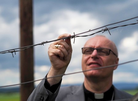 Bischof Ägidius Zsifkovics hinter Stacheldrahtzaun