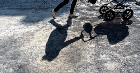 Schatten einer Frau mit Kinderwagen