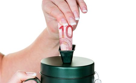 Eine Hand h?lt eine Spendensose. Es wird Geld gesammelt.