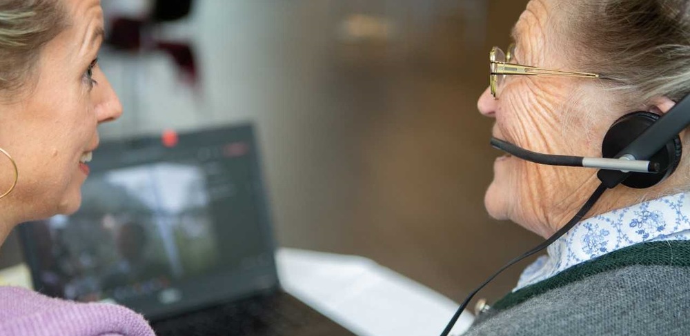 Seniorin mit Begleiterin vor dem Computer