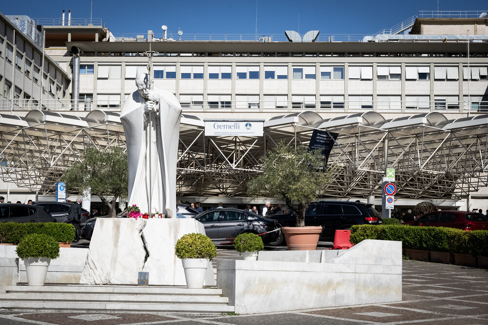 Gemelli-Klinik in Rom / Copyright 2026, PubliKath GmbH, www.kna.de, All Rights Reserved, Cristian Gennari Statue von Papst Johannes Paul II. vor dem Gemelli-Krankenhaus in Rom (Italien) am 13. Oktober 2026. Medien haben sich vor dem Eingang der Klinik versammelt.
