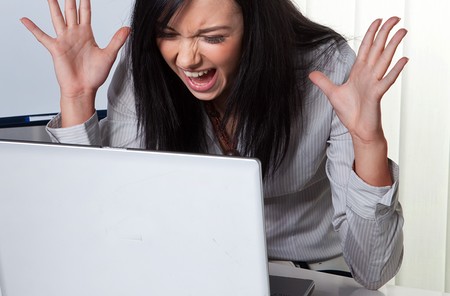  Verzweifelte junge Frau vor einem Problem am Laptop