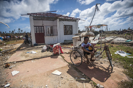 131115-N-BD107-722 GUIUAN, Eastern Samar Province, Republic of the Philippines (Nov. 15, 2013) A Guiuan resident sits in a ricksha outside of his ruined home in the aftermath of Super Typhoon Haiyan. The George Washington Carrier Strike Group support