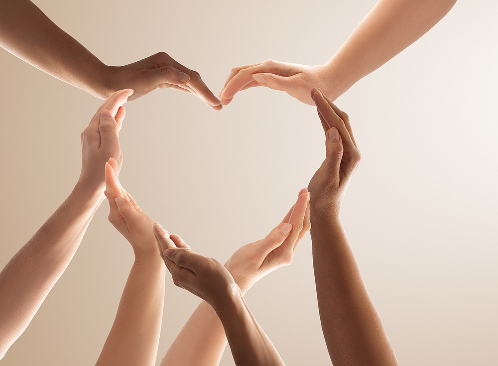 Symbol and shape of heart created from hands.The concept of unity, cooperation, partnership, teamwork and charity.