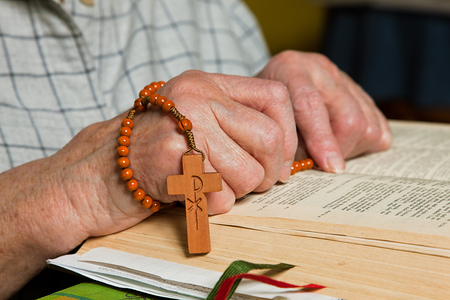 Alte Frau liest in der Bibel und betet