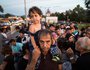 Flüchtlinge warten am 16. September 2015 an der Grenze zwischen Deutschland und Österreich an der Saalbrücke in Freilassing, um von dort in eine Erstaufnahmeeinrichtung gebracht zu werden. Bild: Flüchtlinge drängen sich auf der Brücke. Ein Mann trägt