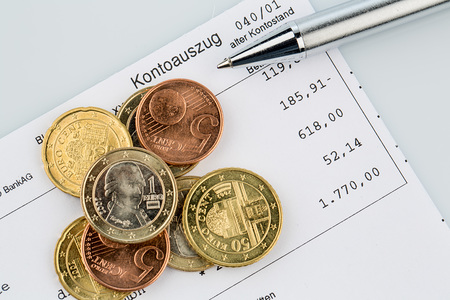 Der Kontoauszug einer Bank und einige M?nzen der Euro W?hrung