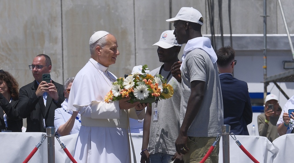 El papa Le?n XIV visita Canarias / Angel Medina G., Angel Medina G., Angel Medina G. ARGUINEGU?N (GRAN CANARIA), 11/06/2026.- El papa Le?n XIV recibe flores de dos voluntarios para protagonizar una ofrenda floral en el mar en recuerdo de los migrantes muertos en la traves?a durante el encuentro con m?s de un millar de inmigrantes de