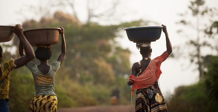 Village of Woroyiri, cocoa producers from the regional cooperative ECOJAD, Member of Ecookim in Côte d'Ivoire. Carrying water for family consumption.