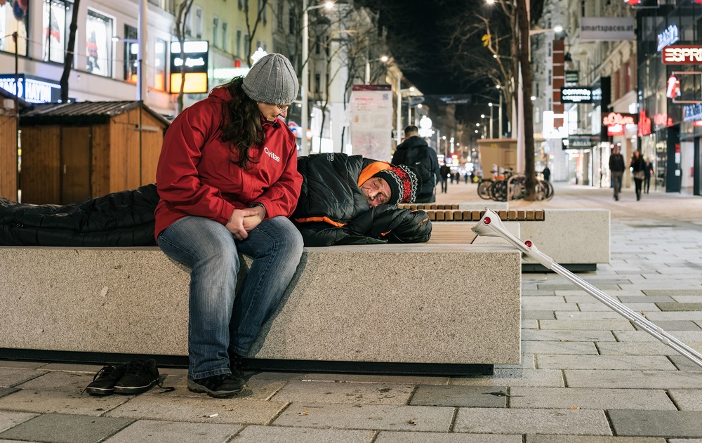 Caritas-Mitarbeiter des Kältebuses hilft Obdachlosem / Caritas Wien