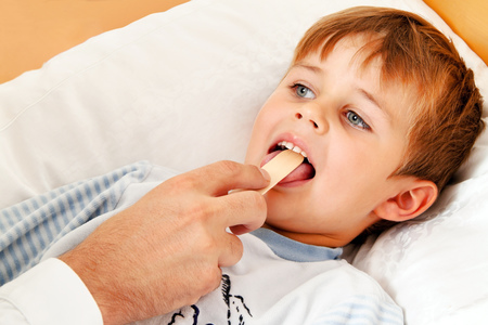 Ein Arzt bei Hausbesuch. Untersucht ein krankes Kind.