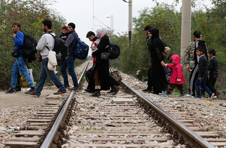 Flüchtlinge überqueren am 19. Oktober 2015 Bahngleise auf dem Weg von dem Transitlager Idomeni durch Mazedonien nach Serbien. Ziel der Flüchtlinge ist der Bahnhof in Belgrad, von dem aus sie mit dem Zug weiterreisen.