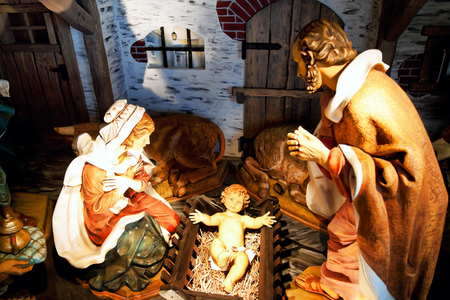 Ein Christkind liegt zu Weihnachten in einer Krippe im Stall.