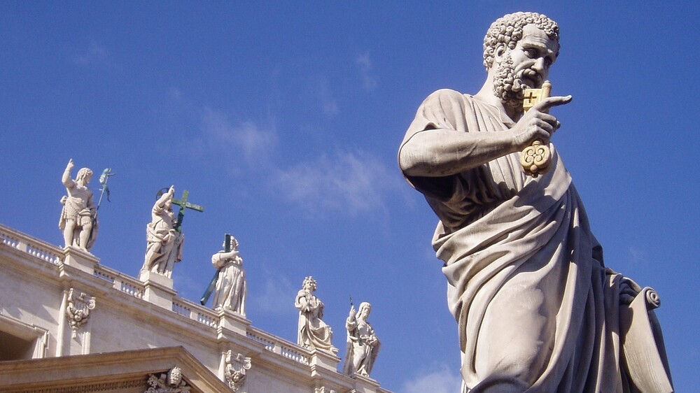 Petrus-Figur, im Hintergrund der Petersdom