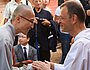 Frere Alois, Prior von Taize, begrüßt einen Vertreter des kambodschanischen Buddhismus am 16. August 2015 zur Gebetsfeier am zehnten Todestag des Taize-Gründers Frere Roger.
