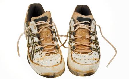 Alte Tennisschuhe von einem Sandplatz. Gebrauchte Sportschuhe.