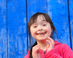 Young girl smiling on background of the blue wall