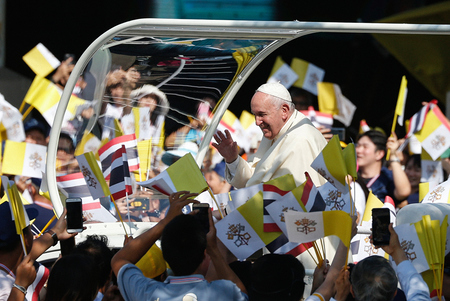 Menschen schwenken Vatikan-Flaggen bei der Ankunft von Papst Franziskus im Papamobil am 22. November 2019 in Bangkok.