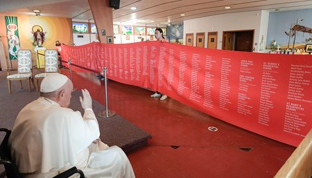 Papst Franziskus segnet in einer Kirche in Maskwacis (Kanada) ein rotes Banner mit Namen von Opfern der Residential Schools bei seinem Besuch am 25. Juli 2022.