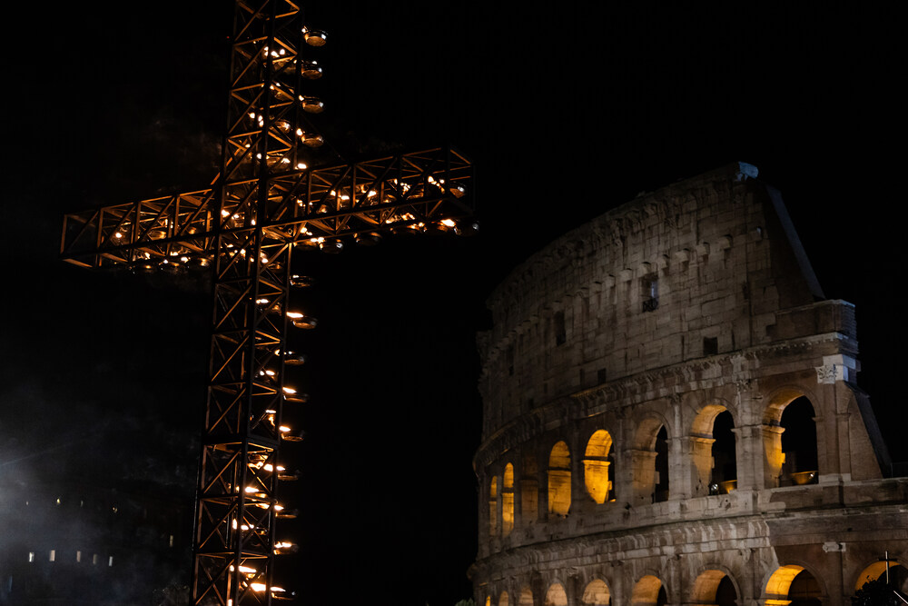 Blick auf das beleuchtete Kreuz mit entzündeten Lichtern vor dem Kolosseum an Karfreitag in Rom (Italien) am 29. März 2024.