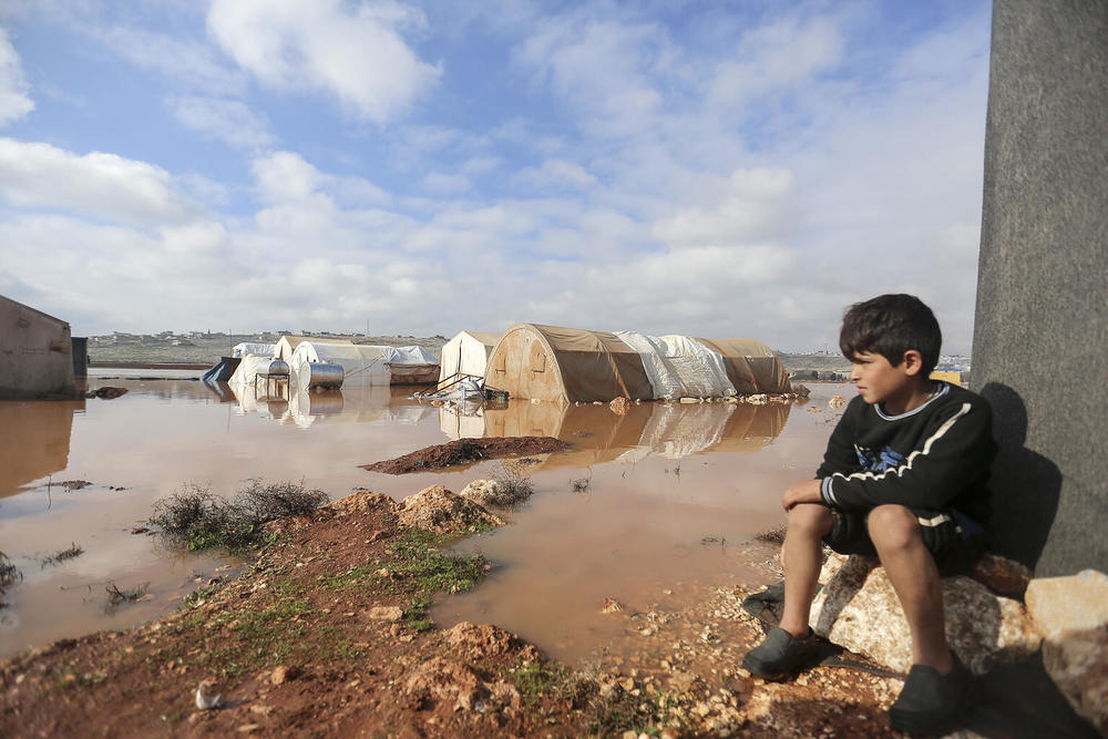 On 19 January 2021, a child looks out over a flooded area of Kafr Losin Camp in northwest Syrian Arab Republic. Over the past few days, western Aleppo and Idlib governorates in the northwest of the country have been experiencing some of the heaviest 