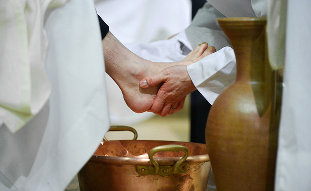 Ein Geistlicher trocknet einem Mann mit einem Handtuch den Fuß während der Fußwaschung an Gründonnerstag, am 24. März 2016 in der Kirche Saint-Jean-Baptiste de Belleville in Paris.