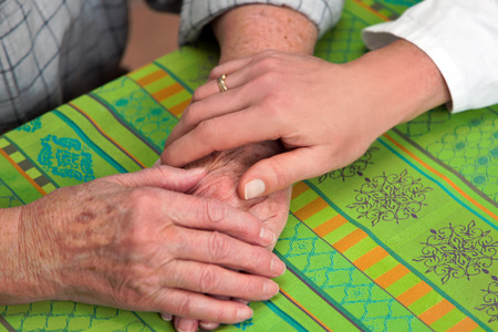 Hand einer Pflegerin und einer alten Seniorin / bildebrox.com