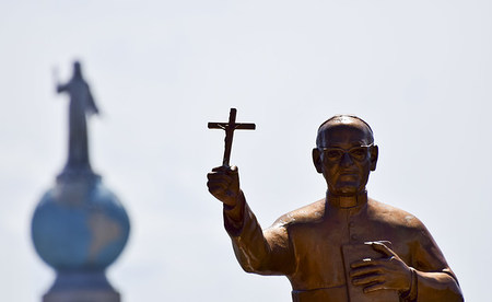 Eine Statue von Oscar Romero steht bei dessen Seligsprechung am 23. Mai 2015 in San Salvador vor dem Denkmal Monumento al Divino Salvador del Mundo, dem Wahrzeichen von El Salvador.